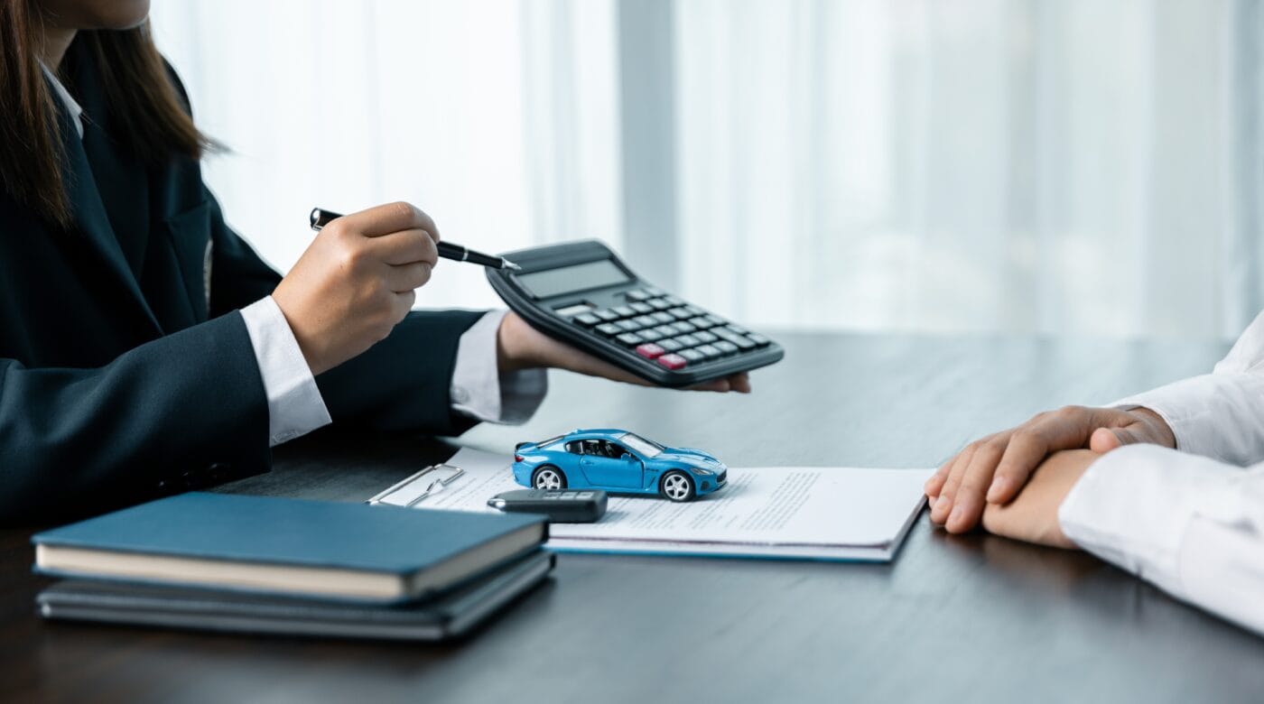 Kundenberaterin rechnet einem Kunden die Finanzierungsmöglichkeiten für ein Auto vor