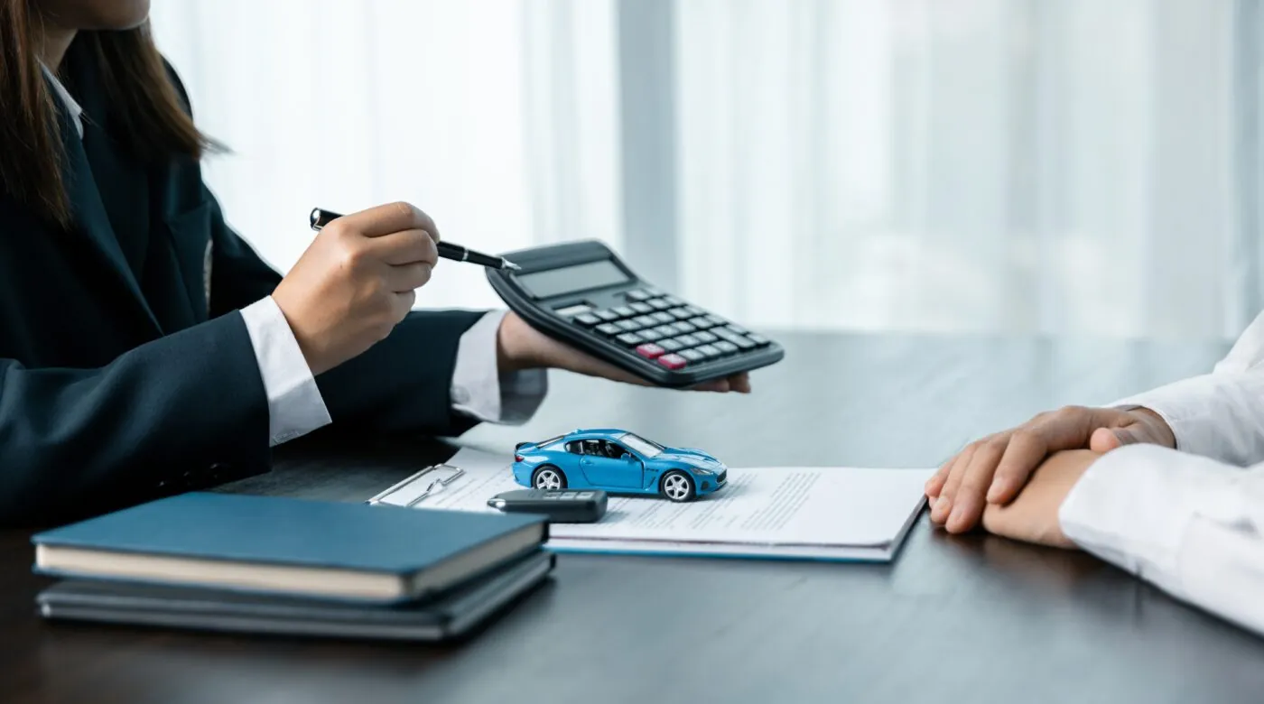 Kundenberaterin rechnet einem Kunden die Finanzierungsmöglichkeiten für ein Auto vor